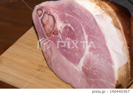 A large piece of HAM on a wooden background. 140440367