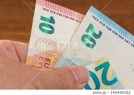 Close-up of 20 and 10 Euro banknotes in hand Close-up of 20 and 10 Euro banknotes in hand 140440382