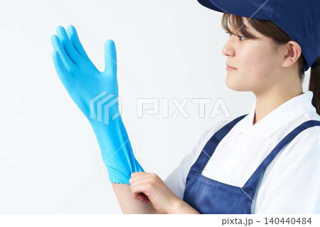 作業前にゴム手袋を装着する女性スタッフ 作業前にゴム手袋を装着する女性スタッフ 140440484