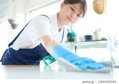 カウンターを拭き上げる若い女性清掃スタッフ カウンターを拭き上げる若い女性清掃スタッフ 140440504