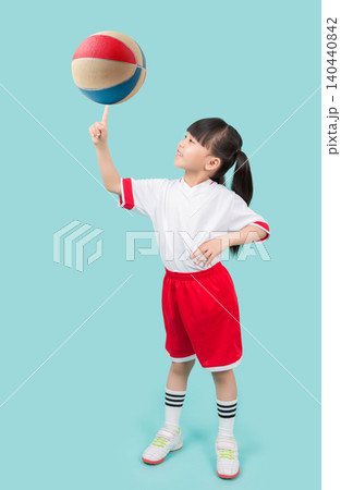 A skillful young girl balancing a colorful toy basketball on the tip of her finger. A skillful young girl balancing a colorful toy basketball on the tip of her finger. 140440842