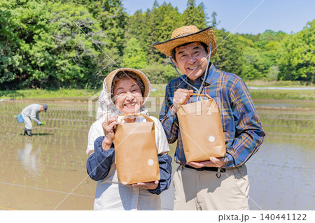 収穫した農産物を手に笑顔を見せるシニア夫婦のポートレート 140441122