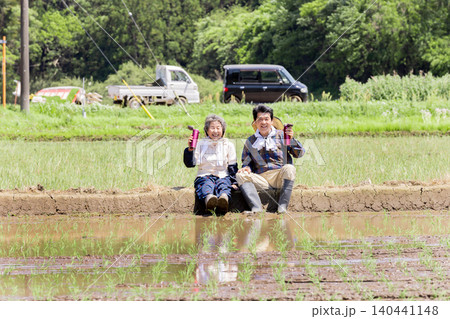 田植え作業の合間に休憩する笑顔のシニア夫婦 田植え作業の合間に休憩する笑顔のシニア夫婦 140441148