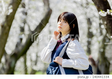 桜並木を歩く女子高校生の春の通学ポートレート 140441334