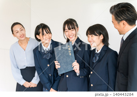 卒業証書を持つ制服,ブレザー姿の小学生,中学生の女の子と男女の教師 卒業証書を持つ制服,ブレザー姿の小学生,中学生の女の子と男女の教師 140443284