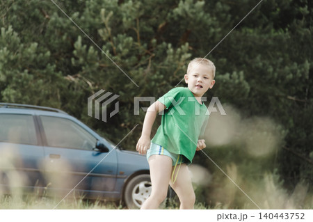 candid shot young boy playing football open grass field. child, wearing green sports jersey, surrounded trees, symbolizing children's sports, outdoor recreation, a healthy lifestyle, family leisure candid shot young boy playing football open grass field. child, wearing green sports jersey, surrounded trees, symbolizing children's sports, outdoor recreation, a healthy lifestyle, family leisure 140443752