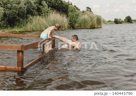 dynamic, relaxed shot boy jumping into natural lake. child is captured mid flight, creating sense excitement. image perfect family vacations, water safety, promoting active lifestyle among children dynamic, relaxed shot boy jumping into natural lake. child is captured mid flight, creating sense excitement. image perfect family vacations, water safety, promoting active lifestyle among children 140443790