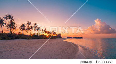 Stunning tropical sunset beach with palm trees. Golden light spilling across white sand and calm shore. Peaceful paradise seascape at glowing dusk. Inspirational summer vacation travel background Stunning tropical sunset beach with palm trees. Golden light spilling across white sand and calm shore. Peaceful paradise seascape at glowing dusk. Inspirational summer vacation travel background 140444351