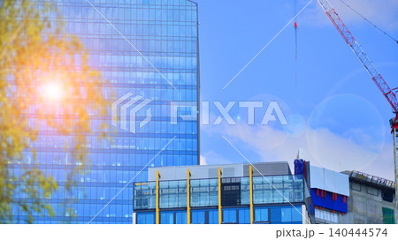 Crane on the construction site in a site surrounded by the high buildings. Office building under construction in the vicinity of high apartment buildings and office building. Crane on the construction site in a site surrounded by the high buildings. Office building under construction in the vicinity of high apartment buildings and office building. 140444574