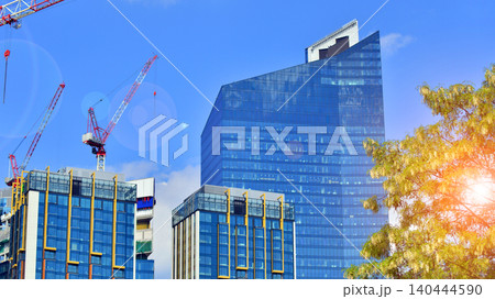 Crane on the construction site in a site surrounded by the high buildings. Office building under construction in the vicinity of high apartment buildings and office building. 140444590