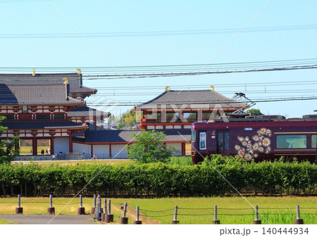 世界遺産平城宮跡内の復元遺跡を横目に走行する近鉄の観光特急『あをによし』 世界遺産平城宮跡内の復元遺跡を横目に走行する近鉄の観光特急『あをによし』 140444934