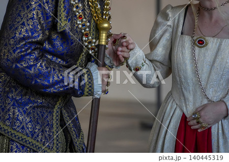 Royal Costume Hand With Jeweled Rings And Cane In Blue Gold Brocade Attire At Event 140445319