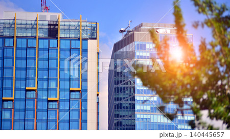 Sustainable glass office building with trees for reducing carbon dioxide. Eco-friendly building in modern city. Office with green environment. Corporate building reduce CO2. Sustainable glass office building with trees for reducing carbon dioxide. Eco-friendly building in modern city. Office with green environment. Corporate building reduce CO2. 140445657