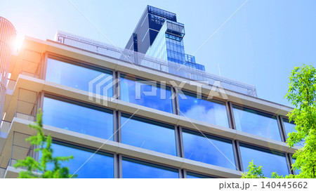 Sustainable glass office building with trees for reducing carbon dioxide. Eco-friendly building in modern city. Office with green environment. Corporate building reduce CO2. 140445662