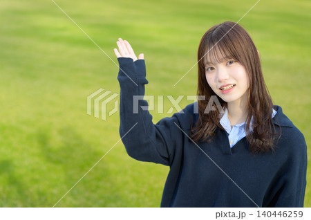 芝生の前で手を上げる日本人女子高生 芝生の前で手を上げる日本人女子高生 140446259