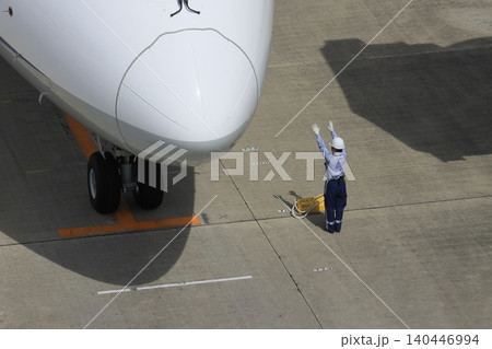 旅客機を誘導するグランドハンドラー 旅客機の到着 グラハンのハンドサイン 旅客機を誘導するグランドハンドラー 旅客機の到着 グラハンのハンドサイン 140446994