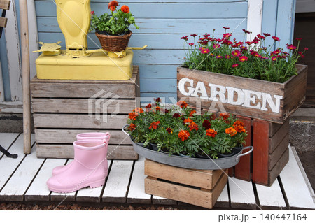 Colorful garden shop display with potted flowers, wooden crates and vintage scale outside storefront Colorful garden shop display with potted flowers, wooden crates and vintage scale outside storefront 140447164