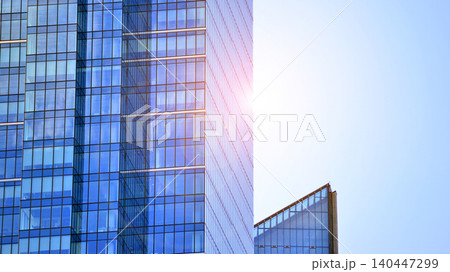 Modern office building with glass facade on a clear sky background. Transparent glass wall of office building. 140447299