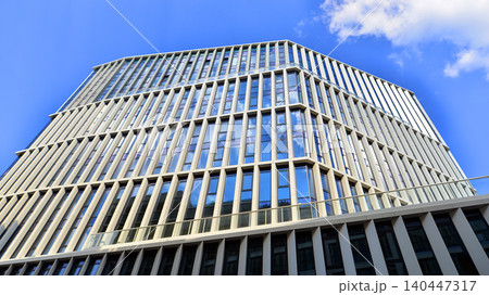 Modern office building with glass facade on a clear sky background. Transparent glass wall of office building. 140447317