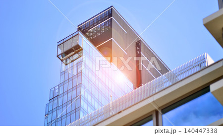 Modern office building with glass facade on a clear sky background. Transparent glass wall of office building. Modern office building with glass facade on a clear sky background. Transparent glass wall of office building. 140447338