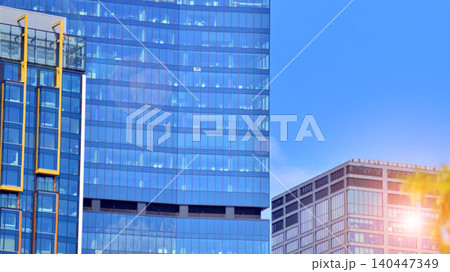 Modern office building with glass facade on a clear sky background. Transparent glass wall of office building. 140447349