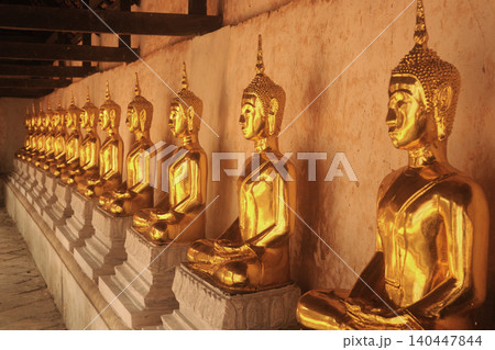 The ancient Buddha images are lined up in the cloister on a Church of Wat Khanon, which also serves as a venue for traditional Thai shadow puppet shows in Thailand. The ancient Buddha images are lined up in the cloister on a Church of Wat Khanon, which also serves as a venue for traditional Thai shadow puppet shows in Thailand. 140447844