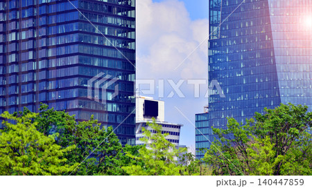 Modern office building with glass facade on a clear sky background. Transparent glass wall of office building. 140447859