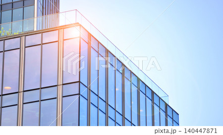 Modern office building with glass facade on a clear sky background. Transparent glass wall of office building. 140447871