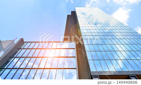 View of modern office building with many windows against clear sky. Glass facade wall. View of modern office building with many windows against clear sky. Glass facade wall. 140448606
