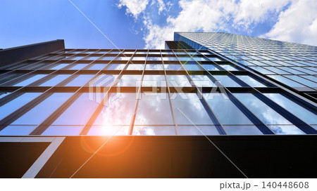 View of modern office building with many windows against clear sky. Glass facade wall. View of modern office building with many windows against clear sky. Glass facade wall. 140448608