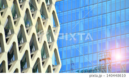 View of modern office building with many windows against clear sky. Glass facade wall. View of modern office building with many windows against clear sky. Glass facade wall. 140448610