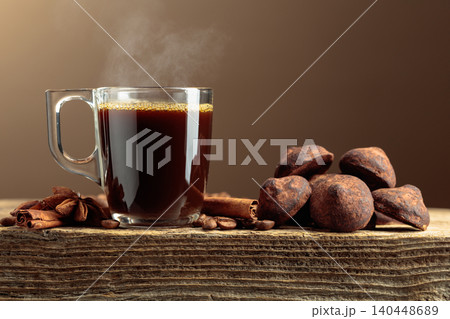 Chocolate truffles and black coffee on a wooden table. 140448689