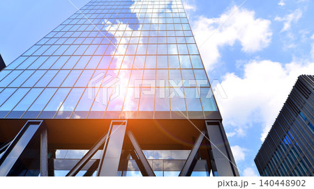 Steel and glass. The subject of modern architecture or construction industry. Modern office building facade with tall steel construction elements and full height windows between. 140448902