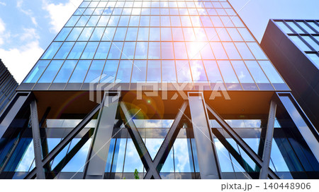 Steel and glass. The subject of modern architecture or construction industry. Modern office building facade with tall steel construction elements and full height windows between. Steel and glass. The subject of modern architecture or construction industry. Modern office building facade with tall steel construction elements and full height windows between. 140448906