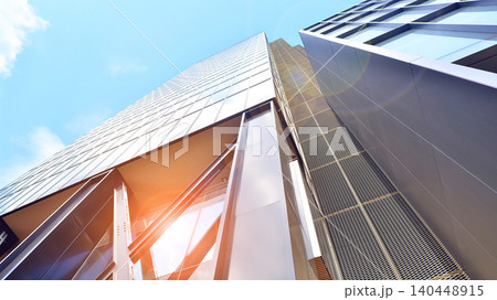 Steel and glass. The subject of modern architecture or construction industry. Modern office building facade with tall steel construction elements and full height windows between. Steel and glass. The subject of modern architecture or construction industry. Modern office building facade with tall steel construction elements and full height windows between. 140448915