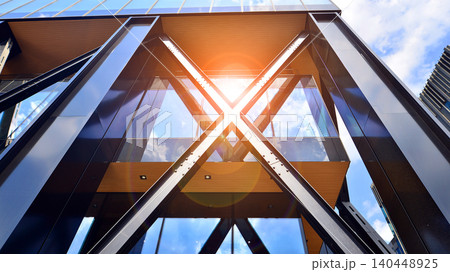 Steel and glass. The subject of modern architecture or construction industry. Modern office building facade with tall steel construction elements and full height windows between. Steel and glass. The subject of modern architecture or construction industry. Modern office building facade with tall steel construction elements and full height windows between. 140448925