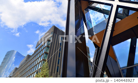 Steel and glass. The subject of modern architecture or construction industry. Modern office building facade with tall steel construction elements and full height windows between. Steel and glass. The subject of modern architecture or construction industry. Modern office building facade with tall steel construction elements and full height windows between. 140448927