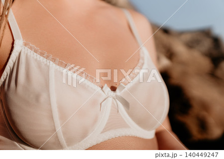 Lingerie bra lace woman wears delicate white underwear standing outdoors in bright natural sunlight during summer Lingerie bra lace woman wears delicate white underwear standing outdoors in bright natural sunlight during summer 140449247