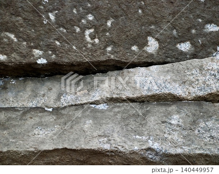 Close-up of weathered layered limestone with lichen patches 140449957