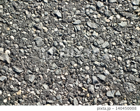 Close-up texture of coarse asphalt with scattered gravel 140450008