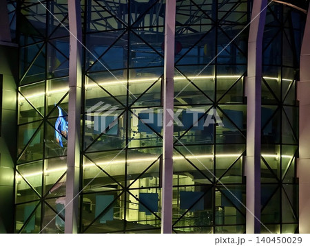 Night view of illuminated modern glass office atrium with curved walkways Night view of illuminated modern glass office atrium with curved walkways 140450029