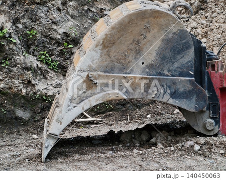 Excavator bucket digging in rocky soil at construction site Excavator bucket digging in rocky soil at construction site 140450063