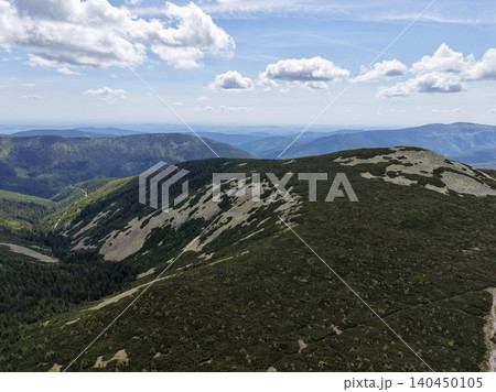 Mountain ridge with alpine shrubs under blue sky and scattered clouds Mountain ridge with alpine shrubs under blue sky and scattered clouds 140450105