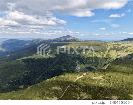 Mountain ridge trail and alpine valley under blue sky 140450109