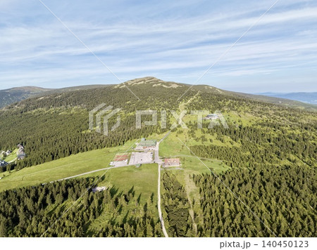 Mountain ridge resort buildings surrounded by forested slopes Mountain ridge resort buildings surrounded by forested slopes 140450123