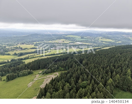 Aerial view of mixed forest and rolling agricultural landscape under overcast sky Aerial view of mixed forest and rolling agricultural landscape under overcast sky 140450134