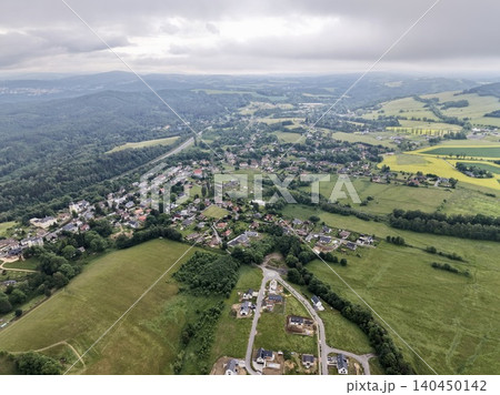 Aerial view of rural village and patchwork farmland under overcast sky 140450142