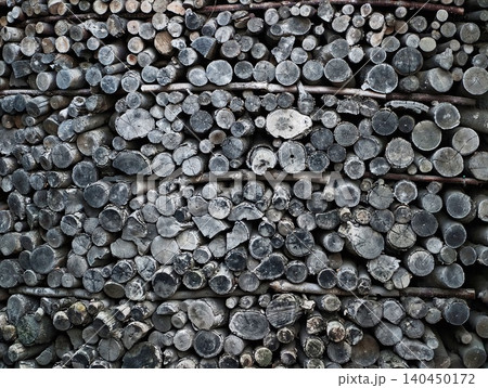 Stacked cut logs in weathered wood pile Stacked cut logs in weathered wood pile 140450172