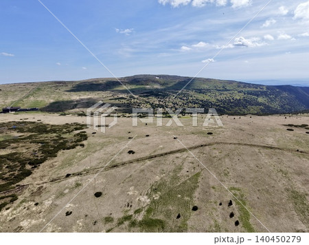 Wide elevated view of windswept upland moor and distant rolling hills under blue sky Wide elevated view of windswept upland moor and distant rolling hills under blue sky 140450279