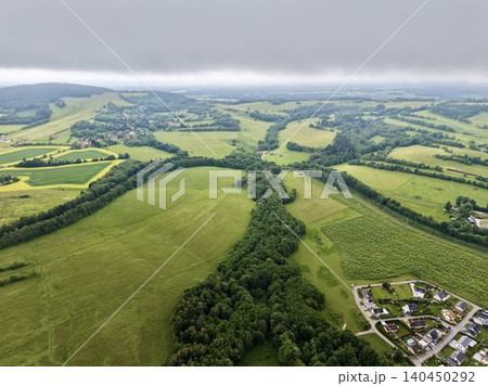 Aerial view of patchwork farmland with tree-lined hedgerows and rural settlement Aerial view of patchwork farmland with tree-lined hedgerows and rural settlement 140450292
